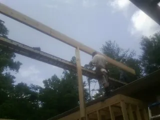 Carpenter setting a ridge beam over a new addition frame — Ice Dam Removal by Roofing Brothers in Cascadia
