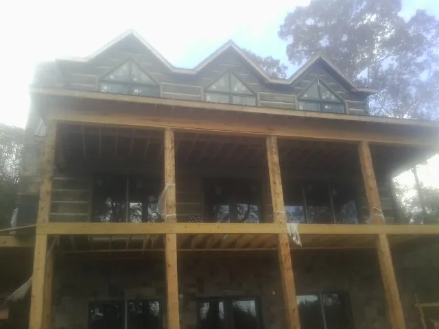 Dormers and porch framing on a large log home under construction — Roof Coating work by our crew in Cascadia